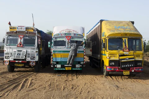 A truck driver cleans the windscreen of a truck as it sits in a parking bay area of a highway service station on National Highway 8 (NH 8) in Rajasthan, India. (Photographer: Udit Kulshrestha/Bloomberg)