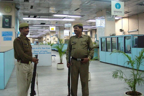 Policemen guard the banking hall of a State Bank of India branch in New Delhi. (Photographer: Sondeep Shankar/Bloomberg News)