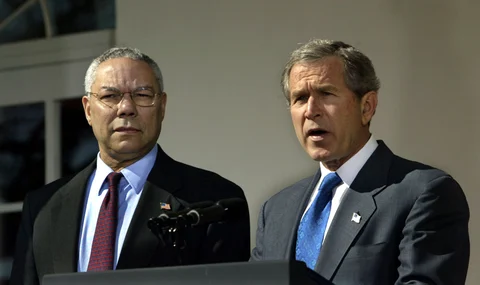 United States President George W Bush, right, speaks in the Rose Garden of the White House in Washington, DC on March 14, 2003 as Secretary of State Colin Powell looks on. (Photographer: Chris Kleponis/Bloomberg News)