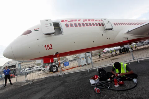 A technician works on the tarmac in front of a Boeing Co. 787-8 Dreamliner aircraft operated by Air India Ltd. (Photographer: Balint Porneczi/Bloomberg)
