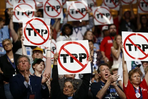 Delegates hold signs against the Trans-Pacific Partnership during the Democratic National Convention in Philadelphia, U.S., on July 25, 2016. (Photographer: Andrew Harrer/Bloomberg)