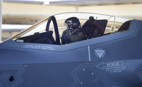 A fighter pilot adjusts his air mask inside the cockpit of a Lockheed Martin Corp. F-35A jet before a training flight in Hill Air Force Base, Utah, U.S. (Photographer: George Frey/Bloomberg)