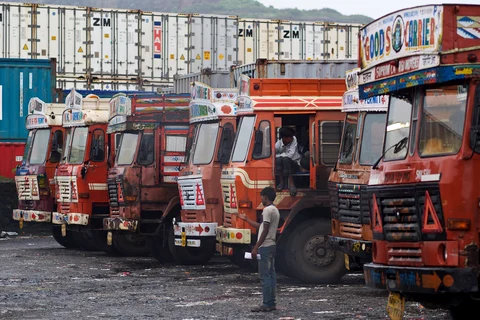 A man directs an unseen truck into a parking space at a freight depot near Nhava Sheva Port in Navi Mumbai, India (Photographer: Adeel Halim/Bloomberg)