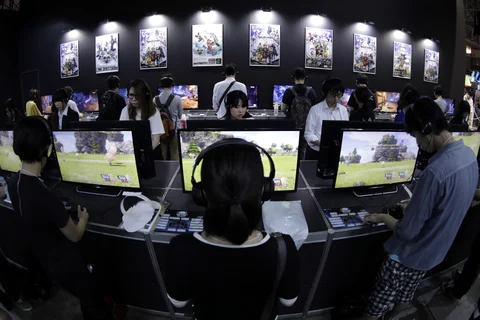 Attendees play video games at the Tokyo Game Show. ( Photographer: Kiyoshi Ota/Bloomberg)