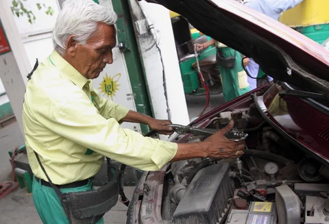 An Indraprastha Gas Ltd. attendant fills up a customer’s car with compressed natural gas (CNG) at a station in New Delhi, India (Photographer: Pankaj Nangia/Bloomberg)