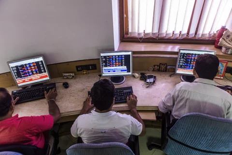 Employees work at their desks in a brokerage firm in Mumbai, India.(Photographer: Prashanth Vishwanathan/Bloomberg)