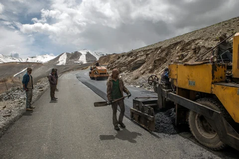 Workers repair the road surface with tarmac on a section of the Leh Manali highway in the Ladakh region, Jammu and Kashmir, India. (Photographer: Prashanth Vishwanathan/Bloomberg)