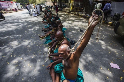 Farmers from Tamil Nadu sit on the ground with rope nooses tied around their necks, during a protest demanding farm loan waivers in New Delhi, India, on March 24, 2017. (Photographer: Prashanth Vishwanathan/Bloomberg)