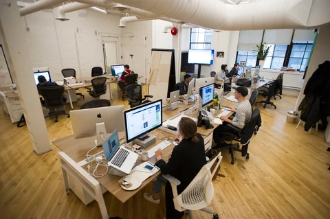 Workers sit at their desks in the Shopify Inc. offices at the company’s headquarters in Toronto, Ontario, Canada. (Photographer: Kevin Van Paassen/Bloomberg)