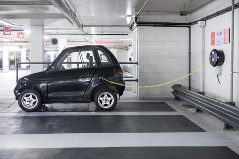 A charging plug connects an electric vehicle (EV) to a charging station at Q-Park Park Lane underground parking lot in London (Photographer: Simon Dawson/Bloomberg)