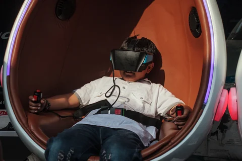 A boy tries out a virtual reality entertainment system at a store in the Mcleod Ganj area of Dharamshala, India. (Photographer: Sara Hylton/Bloomberg)