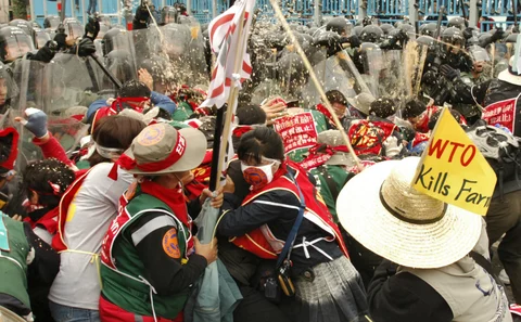 South Korean trade unionists scuffle with riot police and are hit with pepper spray during protests against the WTO’s Sixth Ministerial Conference in Hong Kong, China, December 14, 2005. (Photographer: Michael Caronna/Bloomberg News )