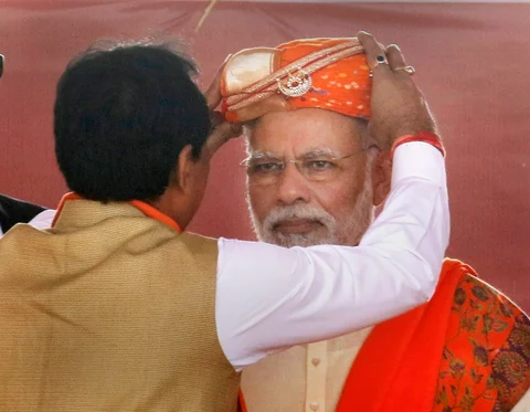 A BJP leader felicitates Prime Minister Narendra Modi during his election campaign rally for assembly election in Lunawada town of Panchmahal district of Gujarat on Saturday. (Source: PTI) 