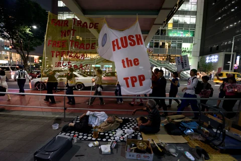 People carry banners during a protest against the Trans-Pacific Partnership trade agreement at the Shibuya district in Tokyo, Japan, on May 26, 2015. (Photographer: Akio Kon/Bloomberg)