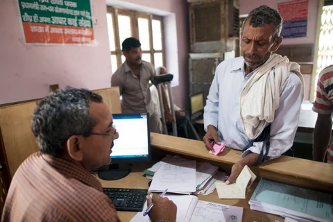 An employee serves a customer inside a branch of Gramin Bank of Aryavat, in the village of Khurana, Uttar Pradesh, India. (Photographer: Prashanth Vishwanathan/Bloomberg)