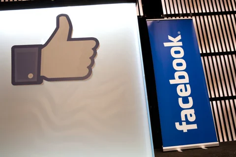 A Facebook Inc. social media logo and a “like” symbol stand on display during a news conference. (Photographer: Duncan Chard/Bloomberg)