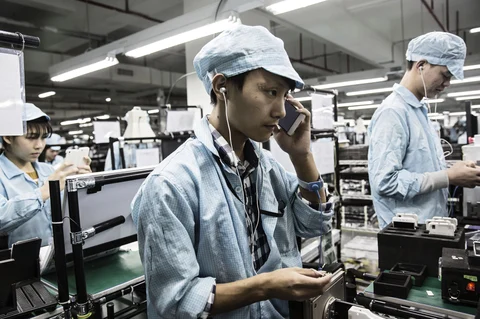An employee tests the headphone port of a OnePlus X smartphone at the OnePlus manufacturing facility in Dongguan, China. (Photographer: Qilai Shen/Bloomberg)