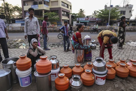 Water commuters wait in line to fill containers at the Vivekananda Chowk water tank in Latur, Maharashtra, India. (Photographer: Dhiraj Singh/Bloomberg)