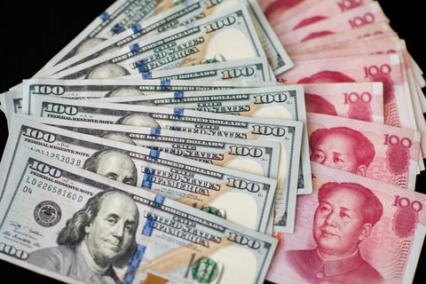 U.S. one-hundred dollar bills and Chinese one-hundred yuan banknotes are arranged for a photograph in Hong Kong, China. (Photographer: Xaume Olleros/Bloomberg)
