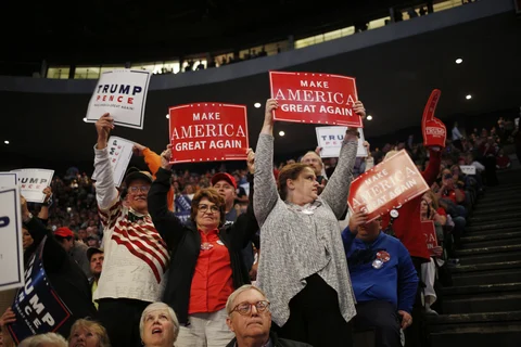 Attendees hold “Make America Great Again” signs during a campaign event for Donald Trump on Oct. 13, 2016. (Photographer: Luke Sharrett/Bloomberg)