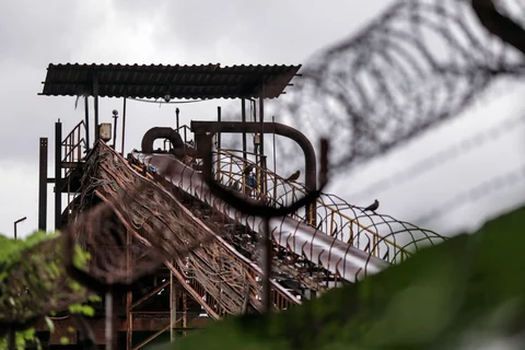 Barbed wire sits atop a fence as a conveyor stands at the JSW Steel Ltd. manufacturing facility in Dolvi, Maharashtra, India. (Photographer: Dhiraj Singh/Bloomberg)