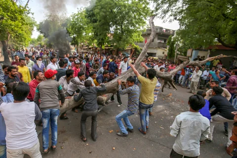 Members of the Dalit community block a road with a tree as they stage a protest during ‘Bharat Bandh’ against the alleged ‘dilution’ of Scheduled Castes/Scheduled Tribes act, in Ahmedabad on April 2, 2018. (Photograph: PTI)