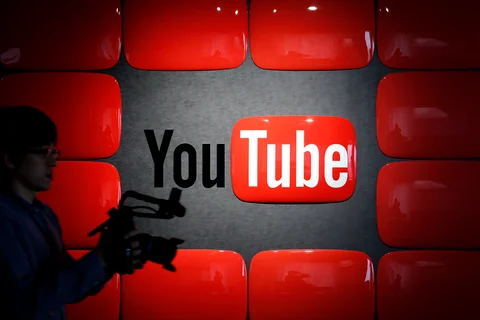 An employee holding recording equipment walks past Google Inc.’s YouTube logo displayed at the company’s YouTube Space studio in Tokyo, Japan (Photographer: Kiyoshi Ota/Bloomberg) 