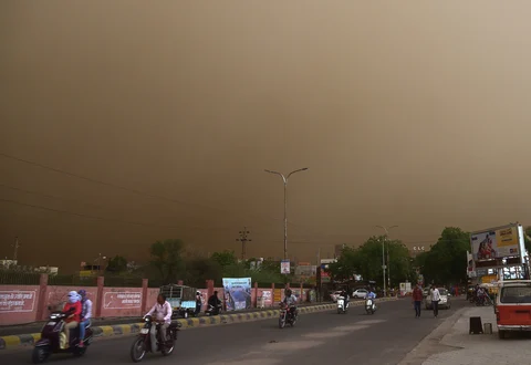 Vehicle ride past on a road during a dust storm in Bikaner on Wednesday. (Source: PTI)