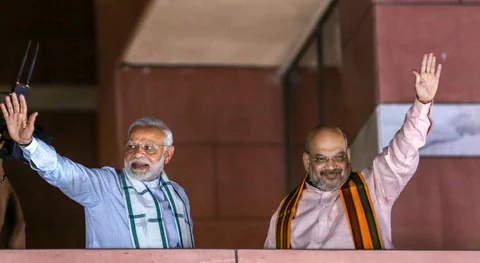Prime Minister Narendra Modi and BJP President Amit Shah wave to party workers gathered at the party headquarters, after the Karnataka Assembly elections result 2018, in New Delhi, on May 15, 2018. (Photograph: PTI)