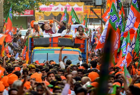 BJP National President Amit Shah campaigns in support of party candidate Katta Subramanya Naidu contesting from Shivajinagar constituency during a road show ahead of the Karnataka Assembly election in Bengaluru. (Photographer: Shailendra Bhojak/PTI)