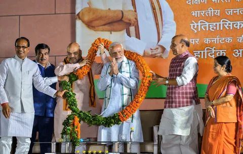 BJP party workers offer milk ‘abhishek’ to cut-outs of Prime Minister Narendra Modi and BJP state unit President BS Yediyurappa as they celebrate BJP’s lead in Karnataka Assembly Election 2018 outside the party office in Bengaluru. (Photographer: Shailendra Bhojak/PTI)