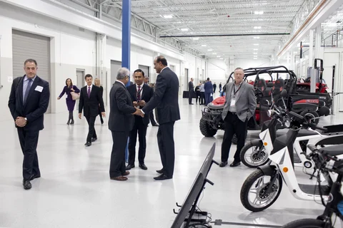 Attendees walk past vehicles at the Mahindra Automotive North America facility in Auburn Hills, Michigan, U.S., on Nov. 20, 2017. (Photographer: Laura McDermott/Bloomberg)