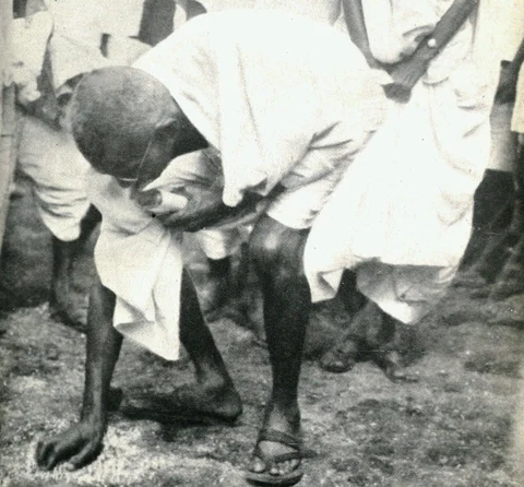 Mahatma Gandhi picks up salt after the march to Dandi, Gujarat, on April 6, 1930. (Photograph: <a href="https://twitter.com/narendramodi">@<b>narendramodi</b></a>/Twitter)