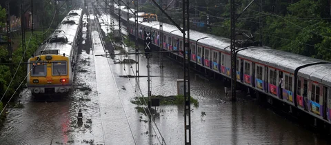 A train chugs on water-logged tracks during heavy rains, in Mumbai. (Source: PTI)