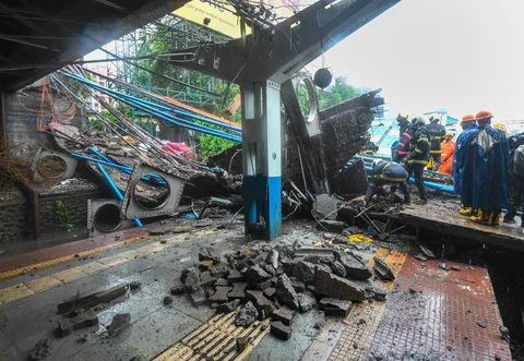 Rescue workers clear the debris of Gokhale foot overbridge that collapsed on the Western Railway tracks, at Andheri station following heavy rain. (PTI Photo/Shirish Shete)