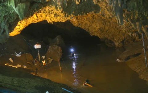 Rescuers walk out of the entrance to a cave complex where 12 soccer team members and their coach went missing, in Mae Sai, Chiang Rai province, in northern Thailand (Source: PTI)