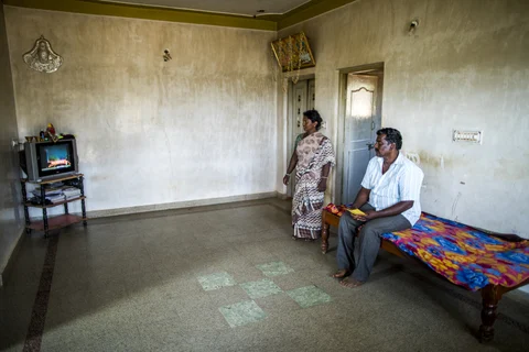 A farmer and his wife watch television in their home in the village of Kuragunda in Karnataka, India, on March 8, 2018. (Photographer: Prashanth Vishwanathan/Bloomberg)