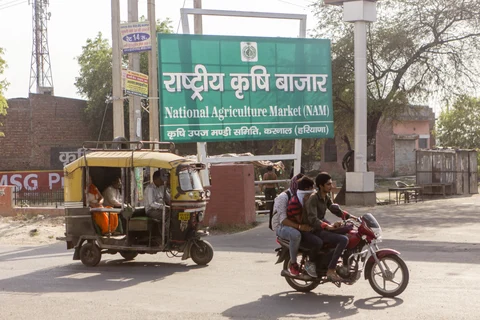 Vehicles travel past an entrance to the National Agricultural Market in Karnal, Haryana, India, on May 19, 2016. (Photographer: Prashanth Vishwanathan/Bloomberg)