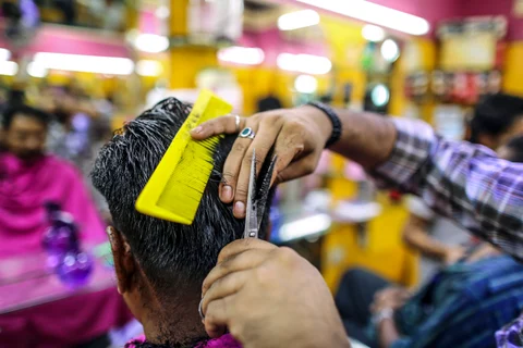 A customer gets a haircut at a barber’s shop in Bangalore, India(Photographer: Dhiraj Singh/Bloomberg)
