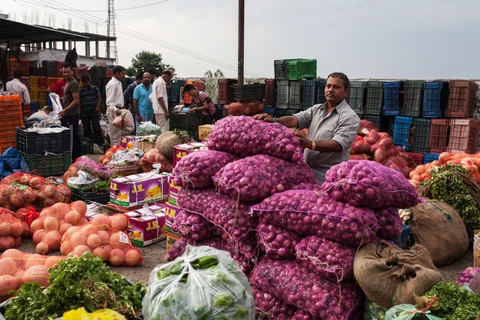 A porter stands next to goods at a wholesale vegetable market in Dharamsala, India. (Photographer: Sara Hylton/Bloomberg)