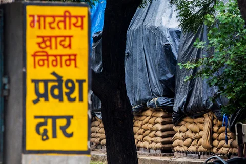 Sacks of wheat sit under tarps while being stored in the open at the site of a Food Corporation of India grain warehouse in Sonepat, Haryana, India. (Photographer: Prashanth Vishwanathan/Bloomberg)
