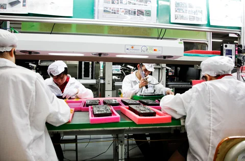 Employees work on the assembly line at Hon Hai Group’s Foxconn plant in Shenzhen, Guangdong province, China. (Photographer: Qilai Shen/Bloomberg)