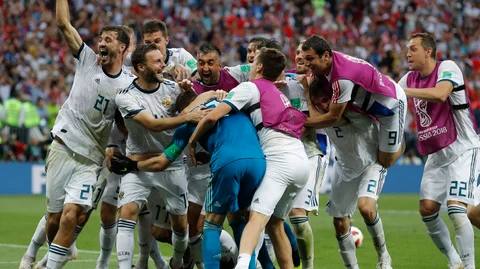 Russian players mob Russia goalkeeper Igor Akinfeev, front left in blue, after Russia defeated Spain by winning a penalty shoot in the round of 16 match between Spain and Russia at the 2018 FIFA World Cup at the Luzhniki Stadium in Moscow, on July 1, 2018. (Photograph: AP/PTI)