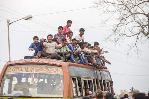Supporters of a political party sit on the roof and in a bus after an election rally in Bankura, West Bengal. (Photographer: Prashanth Vishwanathan/Bloomberg)