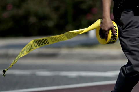 A police office carries crime scene tape in Alexandria, Virginia, U.S. (Photographer: Andrew Harrer/Bloomberg)