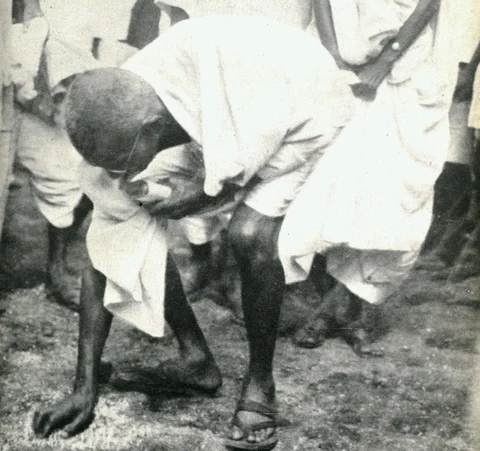 Mahatma Gandhi picks up salt after the march to Dandi, Gujarat, on April 6, 1930. (Photograph: <a href="https://twitter.com/narendramodi">@<b>narendramodi</b></a>/Twitter)