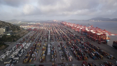 Containers sit stacked next to gantry cranes at the Yangshan Deep Water Port in Shanghai, China, on July 10, 2018. (Photographer: Qilai Shen/Bloomberg)