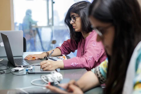 Women work on their laptops at an office in India. (Source: Bloomberg)