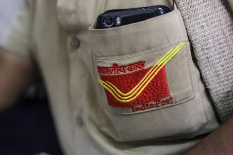 The India Post logo is seen on the shirt of a mail carrier in Mumbai, India. (Photographer: Dhiraj Singh/Bloomberg)