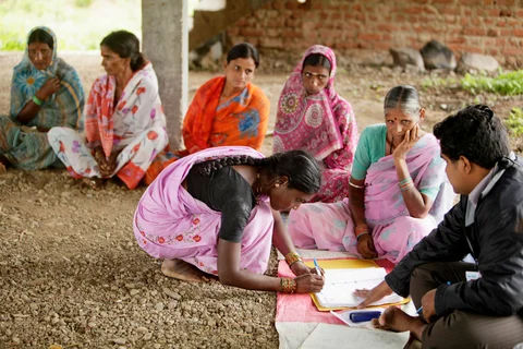 A woman signs a register to receive a microfinance loan. (Photographer: Adeel Halim/Bloomberg)